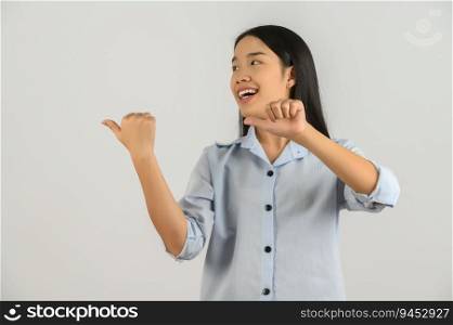 Portrait of young asian woman pointing with two hands and fingers to the side over isolated white background. Advertising and lifestyle concept.