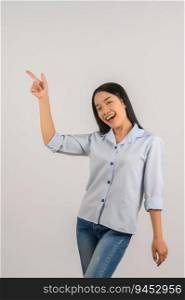 Portrait of young asian woman pointing with two hands and fingers to the side over isolated white background. Advertising and lifestyle concept.