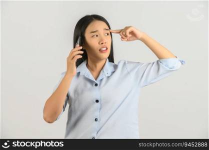 Portrait of Young asian woman talking on mobile phone while standing isolated over white background. Technology concept.
