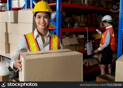 Portrait of young Asian woman warehouse worker smiling in the storehouse . Logistics , supply chain and warehouse business concept .. Portrait of young Asian woman warehouse worker smiling in the storehouse