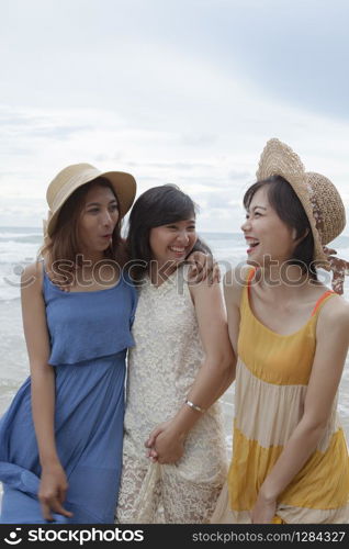 portrait of young asian woman with happiness emotion wearing beautiful dress walking on sea beach and laughing joyful use for people relaxing vacation on destination