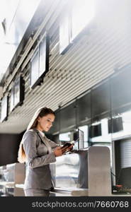 Portrait of young attractive businesswoman looking at her passport in airport