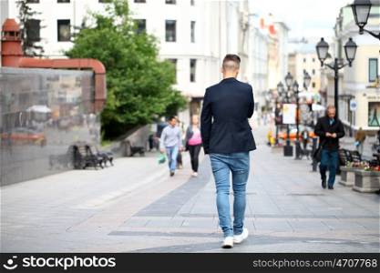 Portrait of young attractive man walking on the street