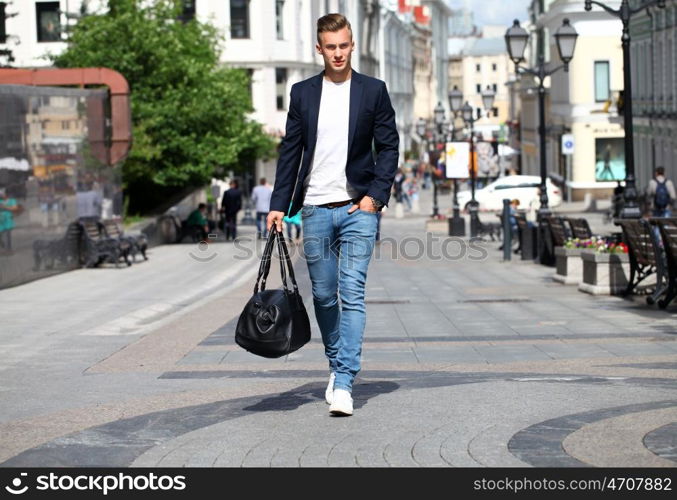 Portrait of young attractive man walking on the street