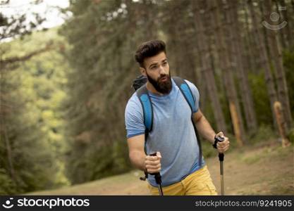 Portrait of young bearded man hiking alone on mountain