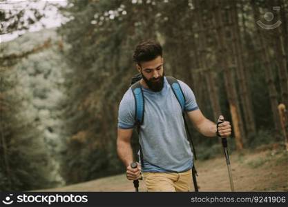 Portrait of young bearded man hiking alone on mountain