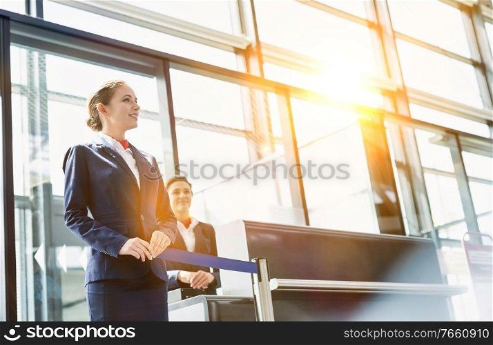 Portrait of young beautiful airport staff opening the gate for boarding in airport