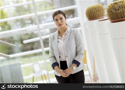 Portrait of young beautiful business woman standing in the modern office