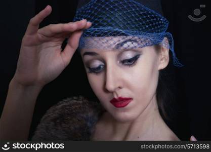 Portrait of young beautiful caucasian woman in veil on black background close up
