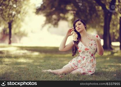 Portrait of young beautiful japanese woman with flowers in her hair, model is an asian beauty in the park.