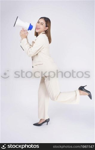 portrait of young beautiful smiling woman in suit using megaphone to announce over isolated white background studio