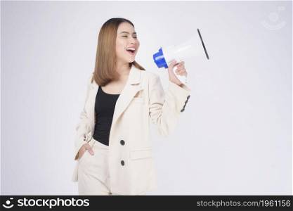 portrait of young beautiful smiling woman in suit using megaphone to announce over isolated white background studio