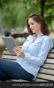 portrait of young beautiful smiling woman with tablet outdoors