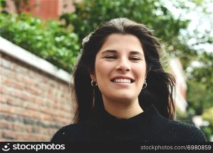 Portrait of young beautiful woman against wall. Outdoors. Urban concept.
