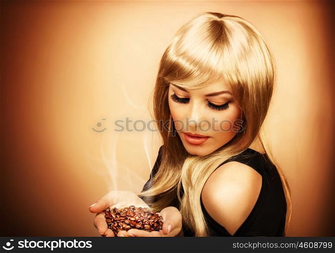 Portrait of young beautiful woman holding hot roasted coffee beans, photo of attractive luxury blonde girl enjoying coffee aroma, image of pretty gorgeous female isolated on brown background