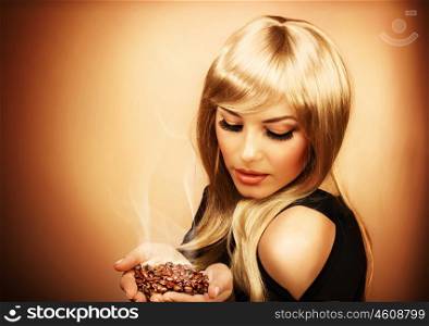 Portrait of young beautiful woman holding hot roasted coffee beans, photo of attractive luxury blonde girl enjoying coffee aroma, image of pretty gorgeous female isolated on brown background