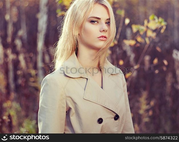 Portrait of young beautiful woman in autumn cloak. Fashion photo. Blonde girl. Perfect make-up