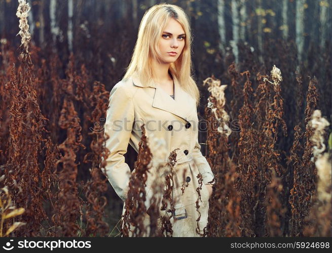 Portrait of young beautiful woman in autumn cloak. Fashion photo. Blonde girl. Perfect make-up