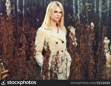 Portrait of young beautiful woman in autumn cloak. Fashion photo. Blonde girl. Perfect make-up