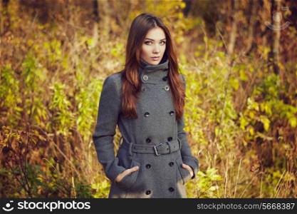 Portrait of young beautiful woman in autumn coat. Fashion photo