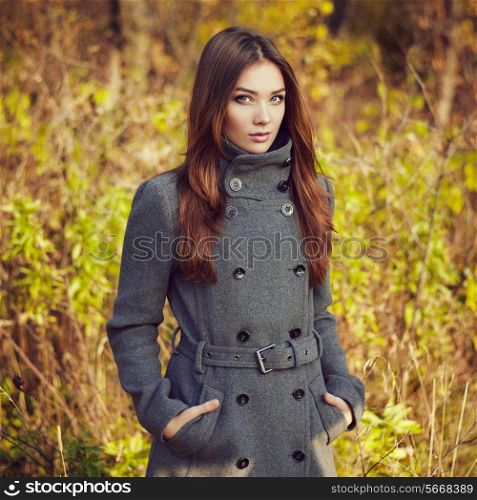 Portrait of young beautiful woman in autumn coat. Fashion photo