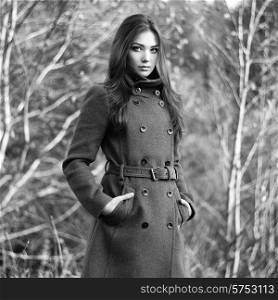 Portrait of young beautiful woman in autumn coat. Fashion photo. Black and white