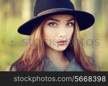 Portrait of young beautiful woman in autumn coat. Girl in hat. Fashion photo