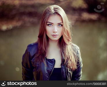 Portrait of young beautiful woman in leather jacket. Fashion photo