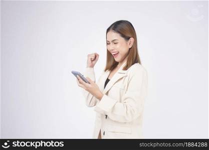 Portrait of young beautiful woman in suit using smart phone over white background