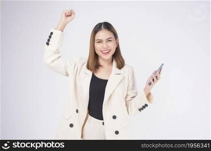 Portrait of young beautiful woman in suit using smart phone over white background