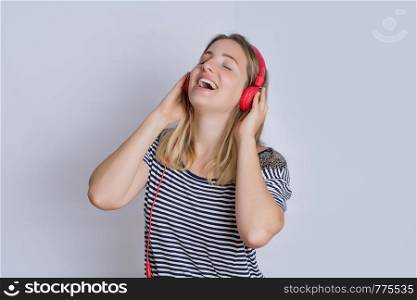 Portrait of young beautiful woman listening to music in studio.
