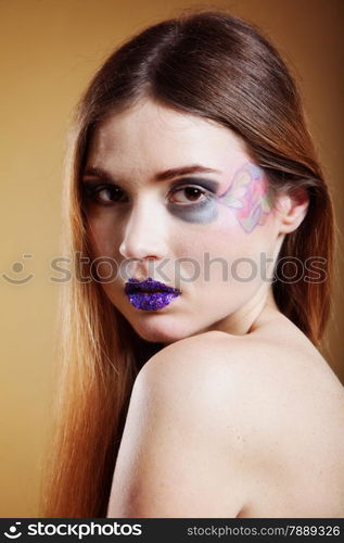 portrait of young beautiful woman long hair colorful make up brown background