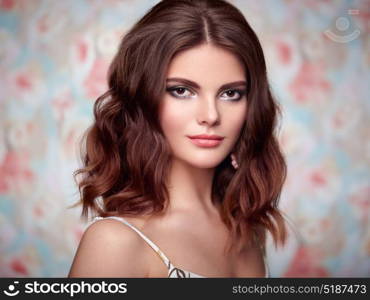 Portrait of young beautiful woman on a background of flowers. Fashion photo. Jewelry and hairstyle. Perfect makeup