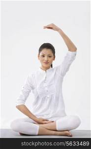 Portrait of young beautiful woman practicing yoga over white background