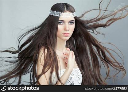 Portrait of young beautiful woman with long flowing hair. Fashion photo