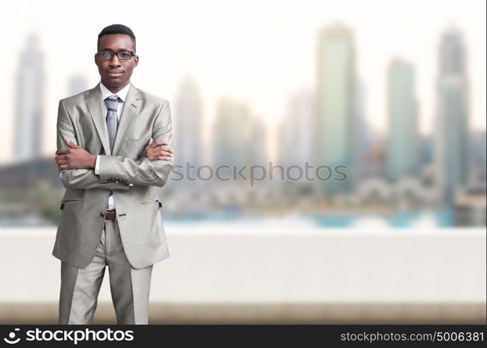 Portrait of young black businessman standing on balcony in front of the big city