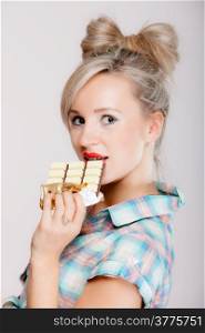 Portrait of young blonde chocolate loving beauty. Sexy girl eating holding chocolate bar on blue background.