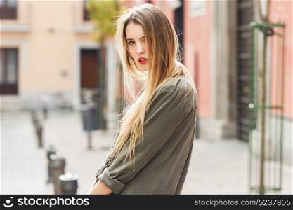Portrait of young blonde girl wearing casual clothes in urban background
