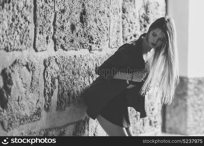 Portrait of young blonde girl wearing casual clothes in urban background