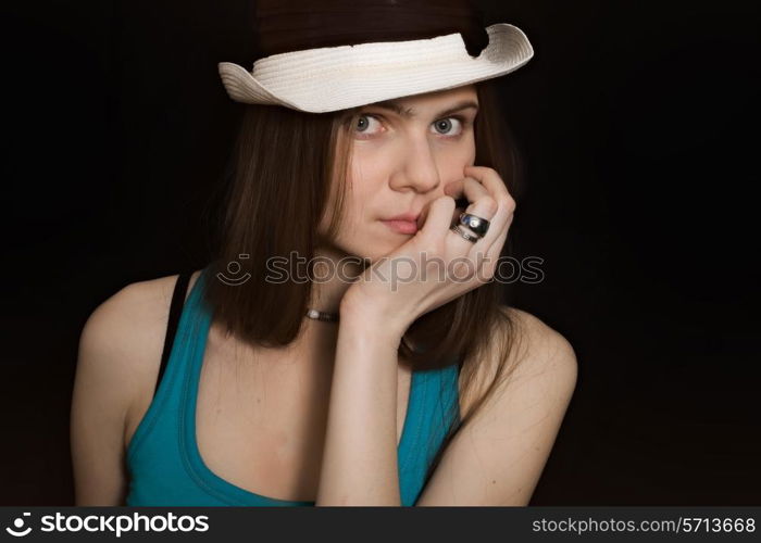 portrait of young blue-eyed girl in white hat on black background&#xA;