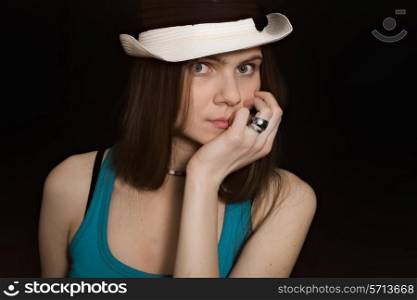 portrait of young blue-eyed girl in white hat on black background&#xA;