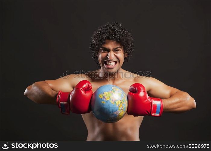 Portrait of young boxer breaking globe