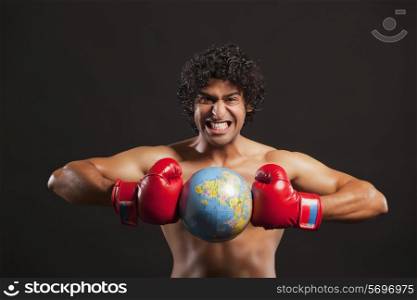 Portrait of young boxer breaking globe