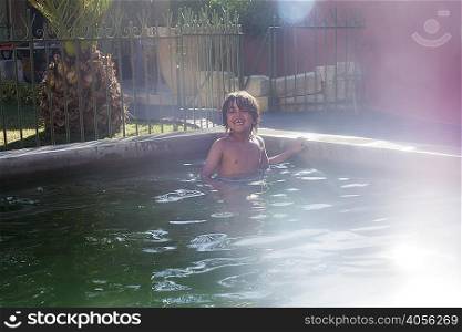 Portrait of young boy in outdoor swimming pool