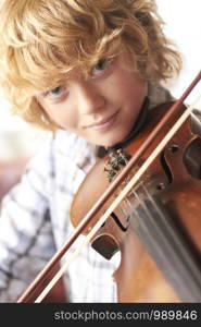 Portrait Of Young Boy Playing Violin At Home