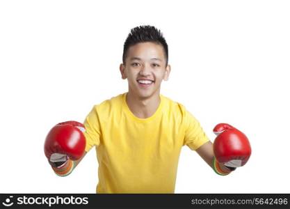 Portrait of young boy wearing red boxing gloves over white background