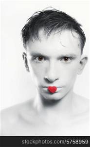 portrait of young brunette man with white skin and red heart on lips