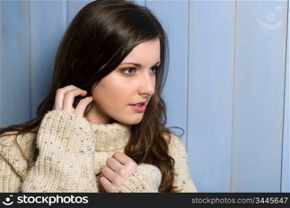 Portrait of young brunette winter woman wearing beige sweater