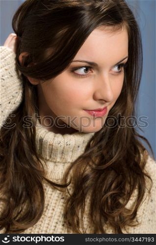 Portrait of young brunette winter woman wearing beige sweater
