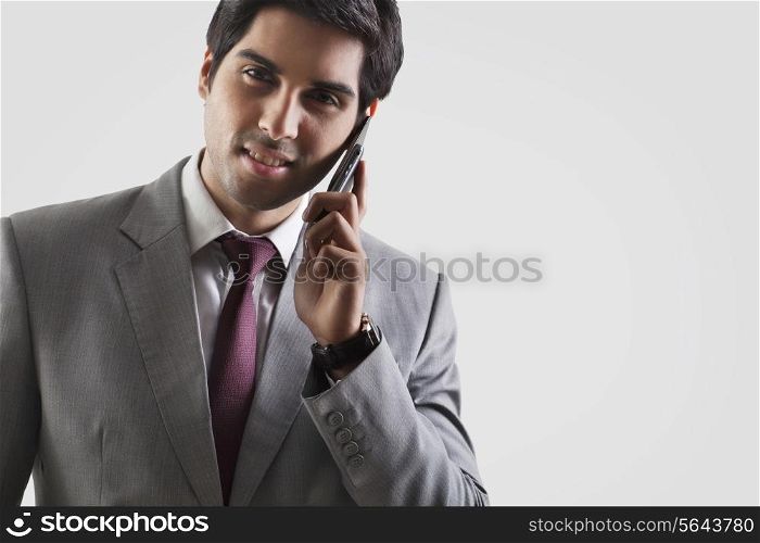 Portrait of young business man having conversation over white background